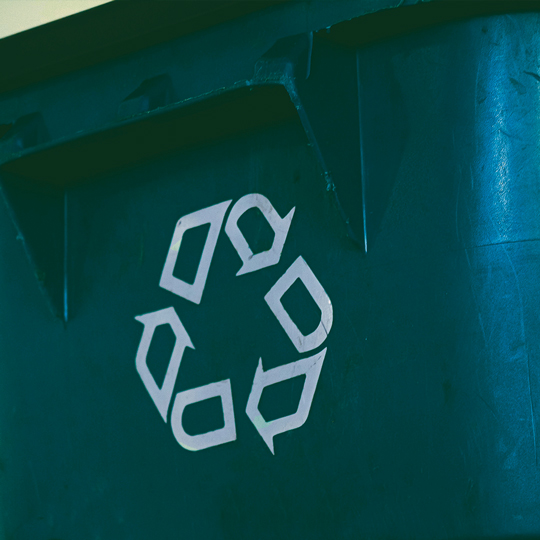 Poubelle verte avec un logo symbolisant le recyclage